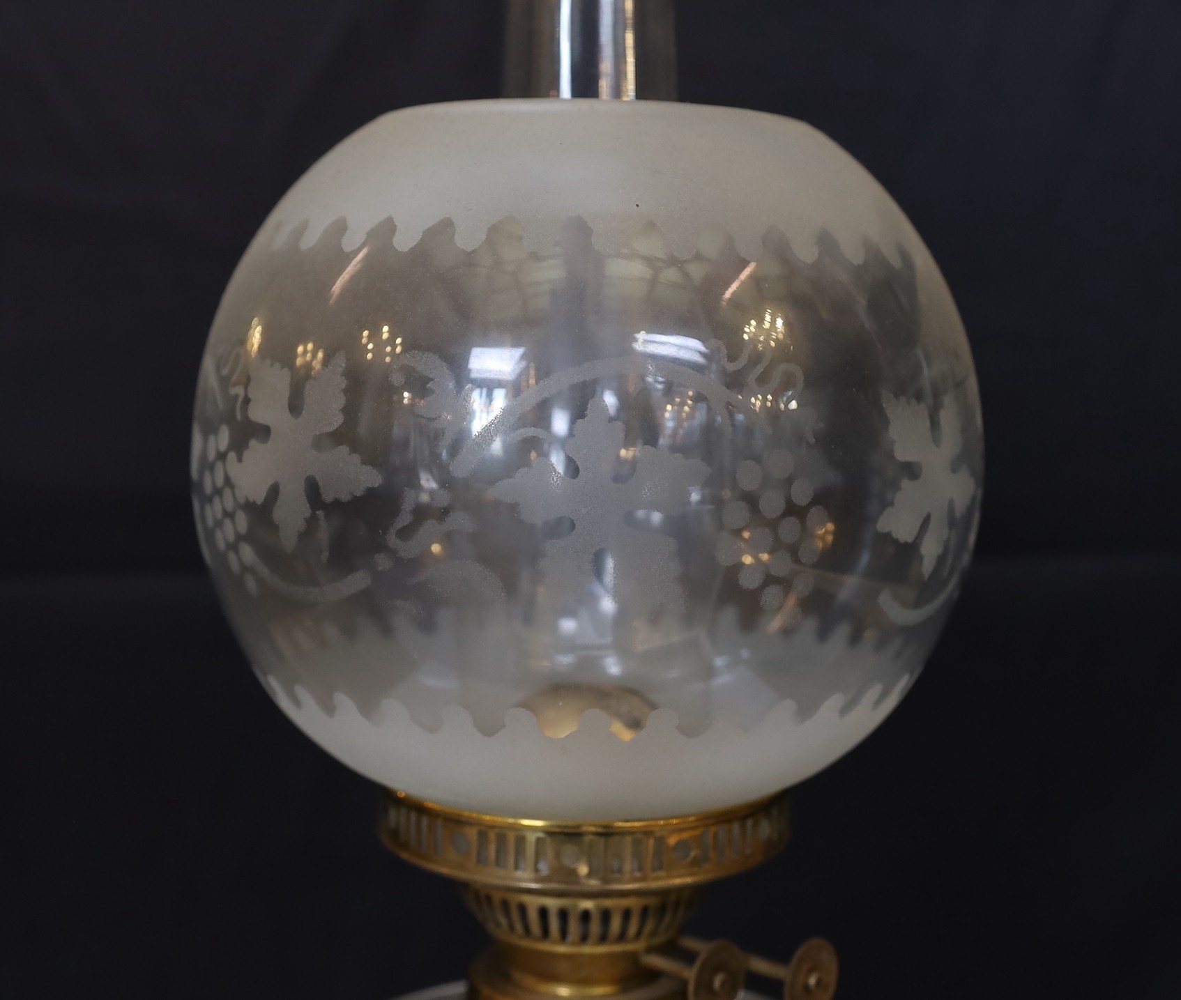 A late Victorian brass oil lamp with cut glass reservoir, duplex mechanism, etched glass globe and flue, height overall 68cm